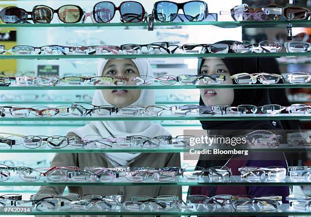Shoppers look at eye glasses at a store inside Sunway Pyramid mall in Petaling Jaya, Malaysia, on Wednesday, March 3, 2010. Bank Negara Malaysia, the...