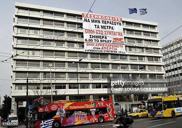 Huge banner reading "Uprise, so the measures won't pass" and calling for demonstrations today and tomorrow hangs from the Finance Ministry building...