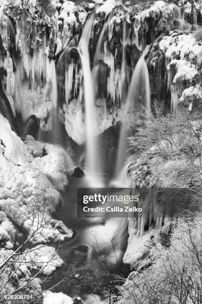 a waterfall beginning to crack through ice. - ice crack stock-fotos und bilder