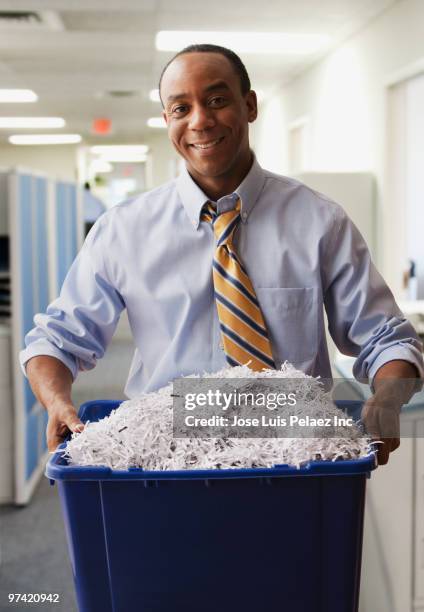 african businessman holding shredded paper for recycling - office recycling stock pictures, royalty-free photos & images