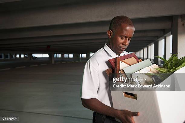 african businessman carrying personal belongings - quitting a job stock-fotos und bilder