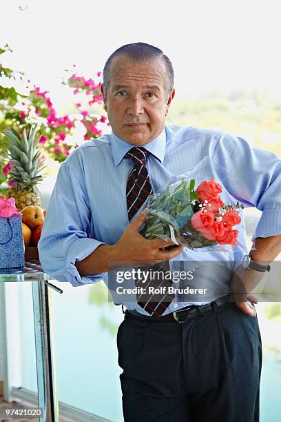 hispanic businessman holding bouquet of flowers - impatience flowers stock pictures, royalty-free photos & images