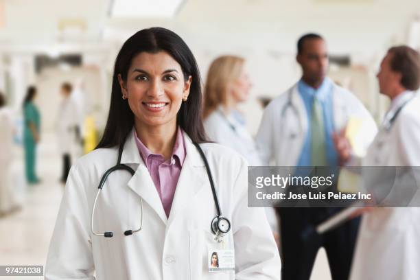 mixed race doctor standing in hospital - arabic doctor stockfoto's en -beelden