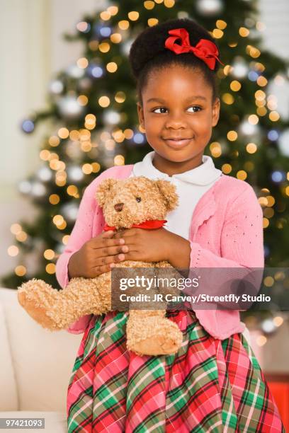 african girl holding teddy bear at christmas - bear den stock pictures, royalty-free photos & images