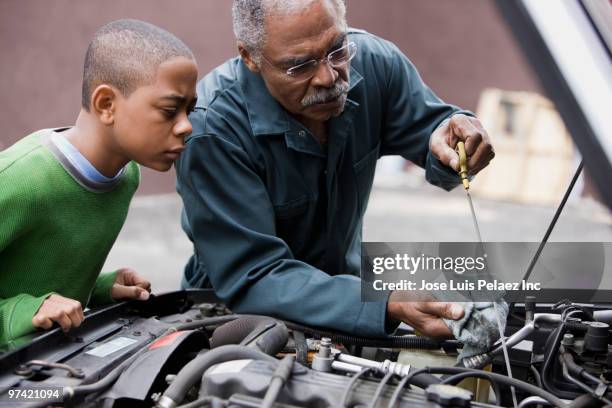 african grandfather and grandson working on car - dipstick stock pictures, royalty-free photos & images