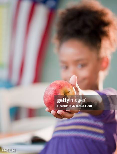 mixed race girl holding apple - teachers pet stock pictures, royalty-free photos & images