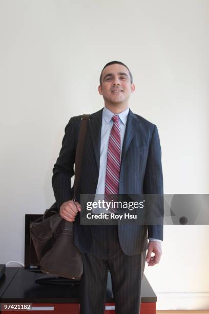 hispanic businessman carrying duffle bag - duffel tas stockfoto's en -beelden