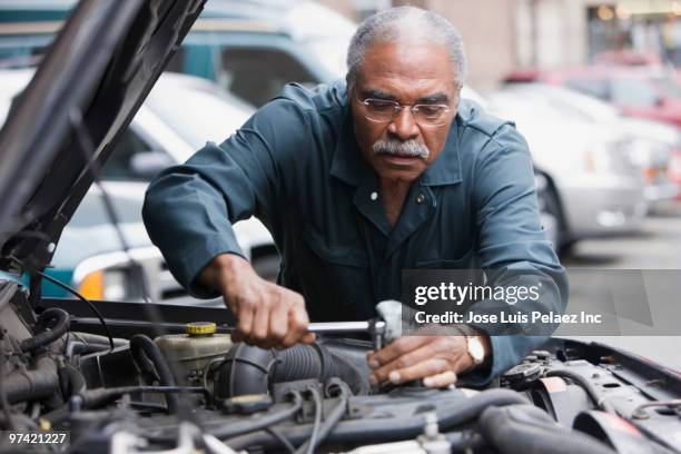 african man working on car - adjusting bildbanksfoton och bilder