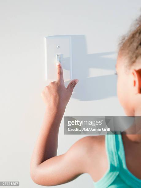 mixed race girl turning off light - light switch stock pictures, royalty-free photos & images