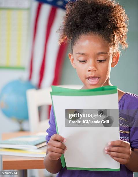 mixed race girl reading report at school - kid presenting stock pictures, royalty-free photos & images