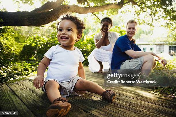 multi-ethnic family enjoying garden - afrikanisches kind beobachtet natur stock-fotos und bilder