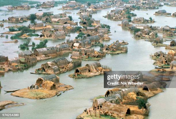 Aerial view of Marsh Arab village of reed huts on small artificial islands in wetlands of Southern Iraq where Tigris and Euphrates rivers meet. The...