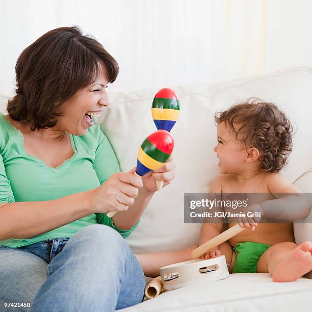 hispanic mother and daughter making music - maracas stockfoto's en -beelden