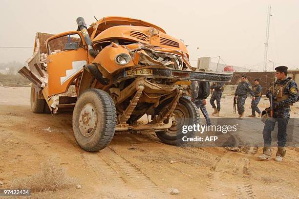 Iraqi security forces inspect an explosives-laden truck which was driven by a suicide bomber and exploded partially due to an error in the connection...