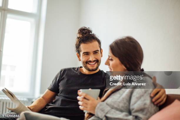 man holding book while looking at woman having coffee - topknot stock-fotos und bilder