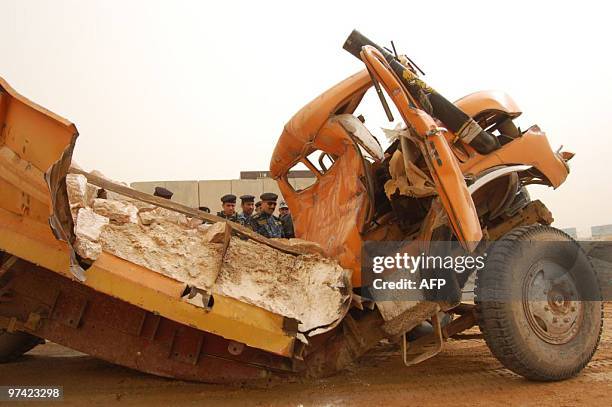 Iraqi security forces inspect an explosives-laden truck which was driven by a suicide bomber and exploded partially due to an error in the connection...