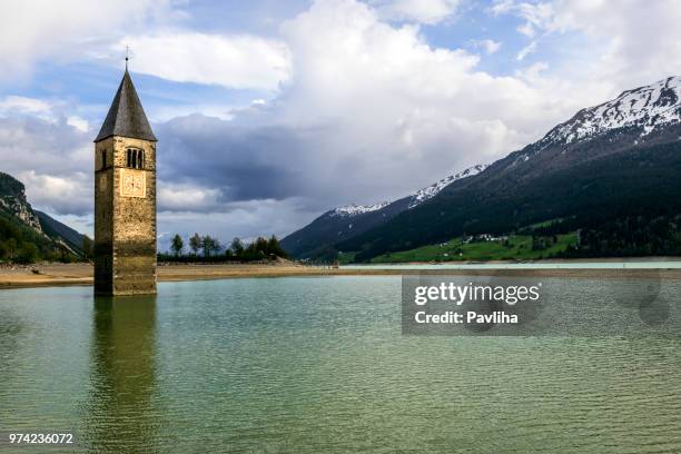 église sous l’eau, noyé le village, le paysage de montagnes et pics en arrière-plan. reschensee lac reschen lago di resia. europe, en italie, tyrol du sud, haut adige, italie, haut-adige - lac-oeschinensee photos et images de collection