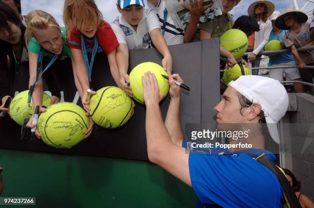 Richard Gasquet of France signs autographs for fans after he wins his second round match in straight sets on Day 3 of the Australian Open at...
