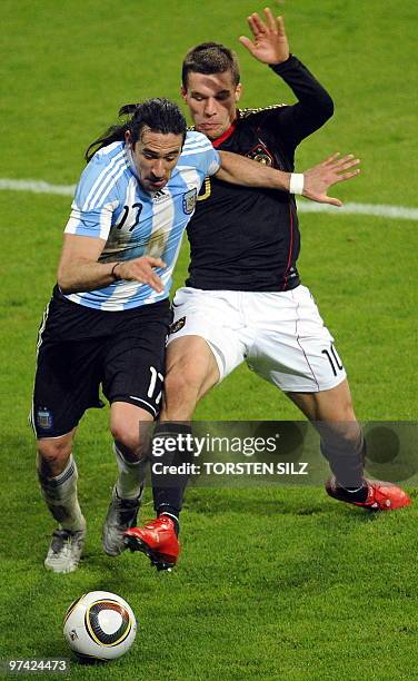 Germany's striker Lukas Podolski rvies for the ball with Argentina's midfielder Jonas Gutierrez during the friendly football match Germany vs...