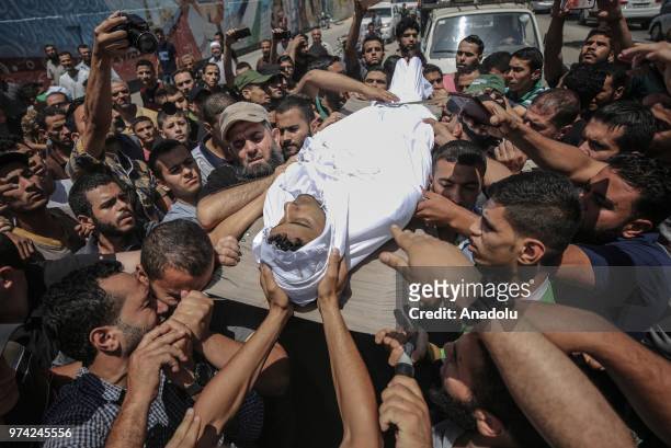People carry the body of 21-year-old Ahmed Ziyad Assi, who was killed when Israeli forces opened fire during "Great March of Returns" demonstrations...