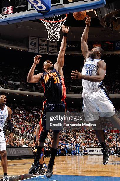 Brandon Bass of the Orlando Magic shoots against Chris Hunter of the Golden State Warriors during the game on March 3, 2010 at Amway Arena in...