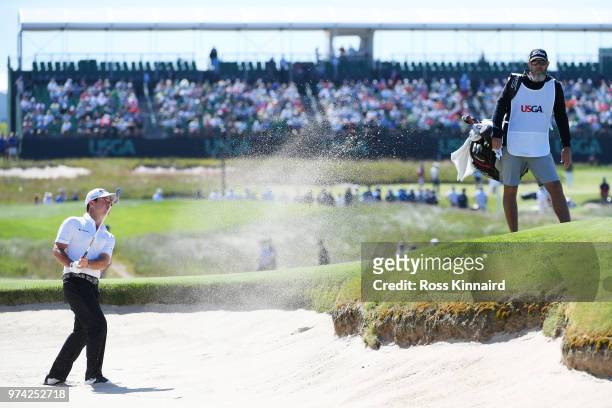 Brian Harman of the United States plays a shot from a bunker on the 17th hole during the first round of the 2018 U.S. Open at Shinnecock Hills Golf...