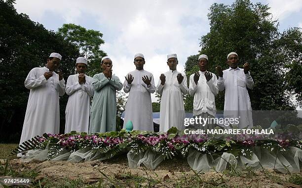 Thai Muslim relatives of a policeman who was killed by suspected separatist militants on February 22 offer prayers during his funeral ceremony in...