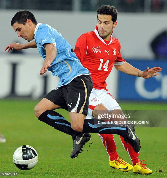 Switzerland's Davide Chiumiento vies with Uruguay's Andres Scotti during the World Cup 2010 friendly football match Switzerland vs Uruguay at AFG...