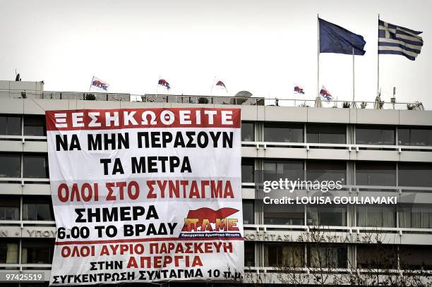 Huge banner reading "Uprise, so the measures won't pass" and calling for demonstrations today and tomorrow hangs from the Finance Ministry building...