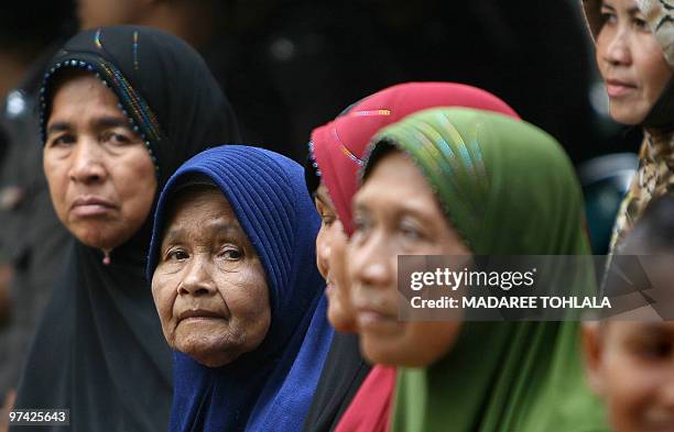 Thai Muslim relatives of a Muslim policeman who was killed by suspected separatist militants on February 22, assemble ahead of his funeral ceremony...