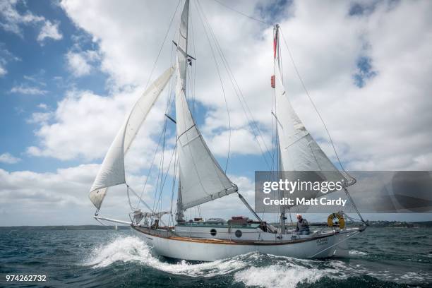 Sir Robin Knox-Johnston sits besides the tiller on his boat Suhaili as he follows behind the competitors taking part in the 2018 Golden Globe Race in...