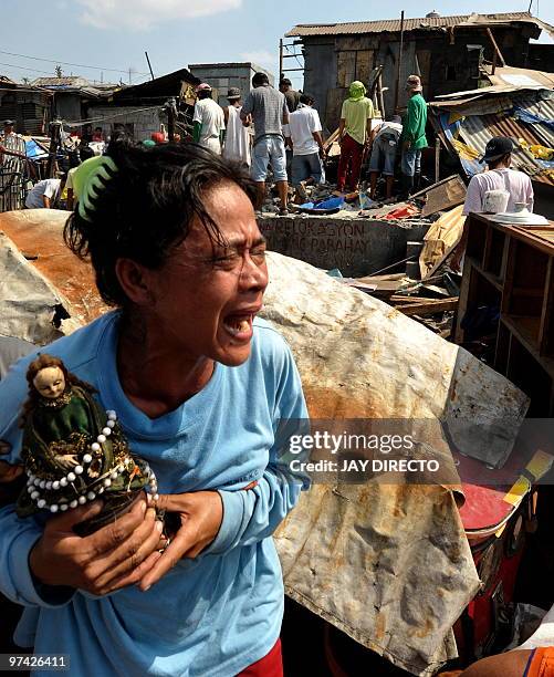 Woman cries as her house is demolished by workers of the Department of Public Work and Highways in Navotas City suburban Manila on March 4, 2010 as...