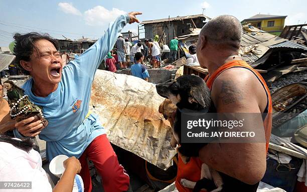 Woman cries as her house is demolished by workers of the Department of Public Work and Highways in Navotas City suburban Manila on March 4, 2010 as...