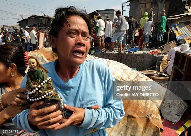 Woman cries as her house is demolished by workers of the Department of Public Work and Highways in Navotas City suburban Manila on March 4, 2010 as...