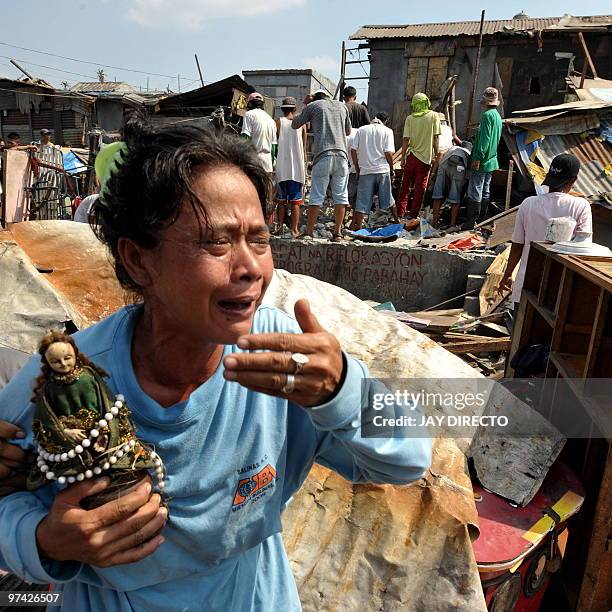 Woman cries as her house is demolished by workers of the Department of Public Work and Highways in Navotas City suburban Manila on March 4, 2010 as...