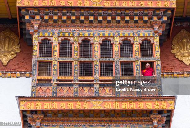 monk in window in punakha dzong in bhutan. - punakha dzong stock pictures, royalty-free photos & images