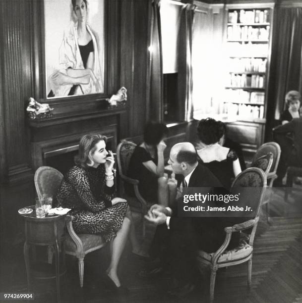 Cocktail party in the living room of Mrs. Harvey Breits's New York apartment, a well planned room in action: In the fireplace area Doris Lilly,...