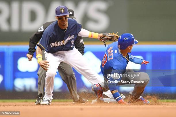 Javier Baez of the Chicago Cubs beats a tag by Orlando Arcia of the Milwaukee Brewers during a game at Miller Park on June 11, 2018 in Milwaukee,...