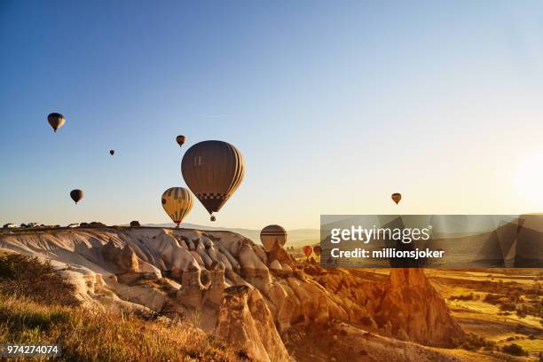 hot air balloons flying at sunset, cappadocia, turkey - cappadocia hot air balloon stock pictures, royalty-free photos & images