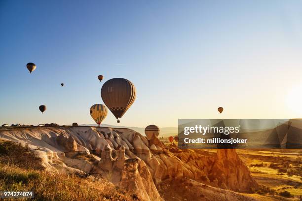 hot air balloons flying at sunset, cappadocia, turkey - balão imagens e fotografias de stock