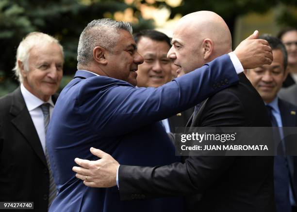 S President Gianni Infantino is embraced by AFA's President Claudio Tapia during the inauguration of the CONMEBOL Casa del Futbol in Moscow, on June...