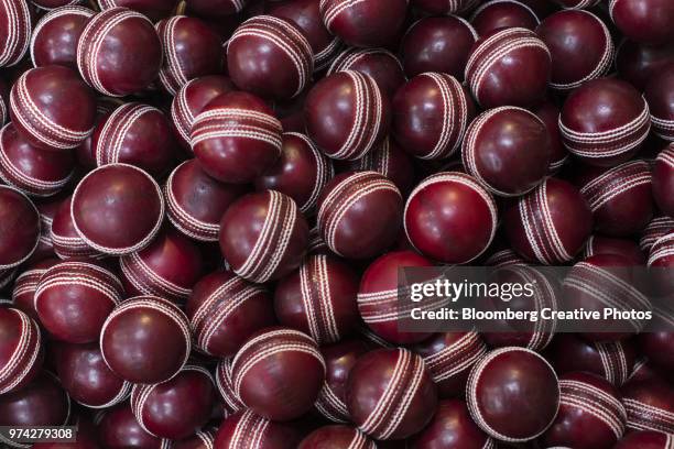 red cricket balls sit in factory - sports india stockfoto's en -beelden