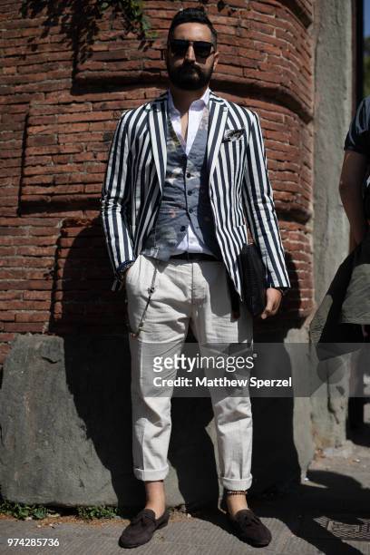 Guest is seen on the street attending Pitti Uomo 94 wearing a stripe blazer, blue pattern vest, white shirt, off-white pants and brown loafers on...