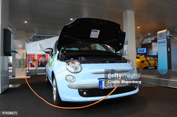 An electric Fiat 500 automobile, featuring an engine modified by RWE, is charged on the opening day of the Geneva International Motor Show in Geneva,...