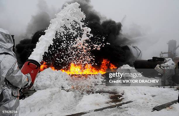 Belarussian Emergency Situations Ministry workers put out a fire 80 km north of Minsk near the village Svetlaya Roshcha on February 26, 2010 during a...