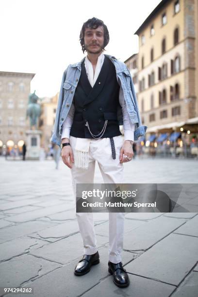 Guest is seen on the street attending Pitti Uomo 94 wearing a denim jacket with navy vest and white pants on June 12, 2018 in Florence, Italy.