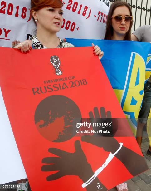 Activists hold placards by artist Andriy Yermolenko during a rally with an appeal to boycott the Russia World Cup 2018 football tournament, and...