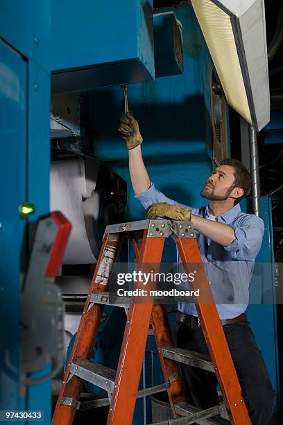 man working in newspaper factory - step ladder stock pictures, royalty-free photos & images