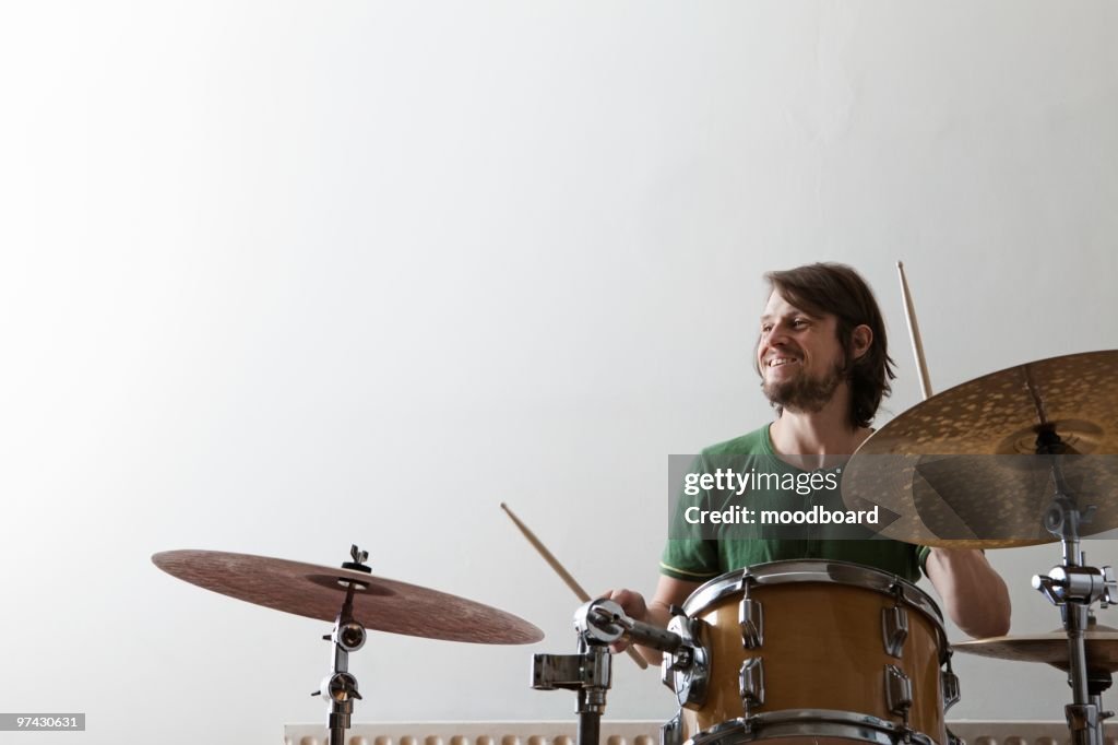 Young man plays drums with enjoyment