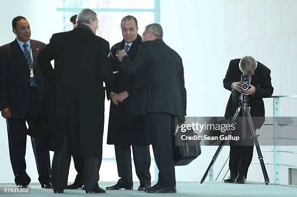 German portrait photographer Konrad R. Mueller checks his camera as he waits for the arrival of Chancellor Angela Merkel and Egyption President Hosni...